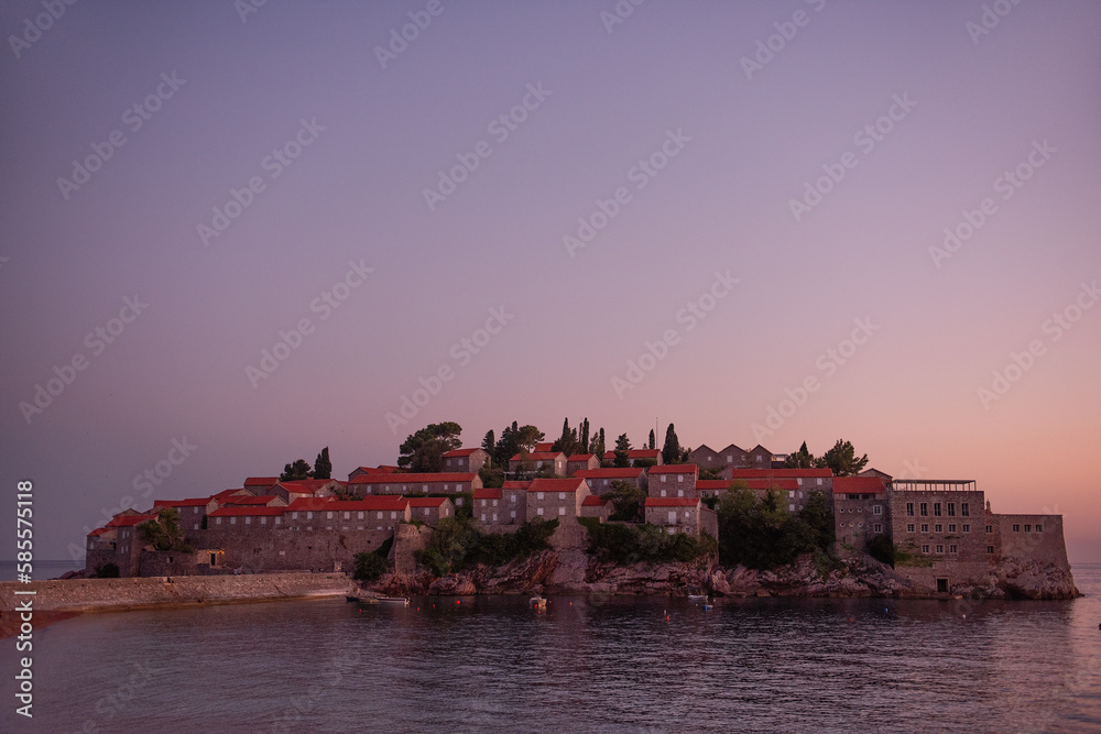 Panoramic view of Sveti Stefan in Montenegro at pink sunset. Famous tourist place near Budva Natural