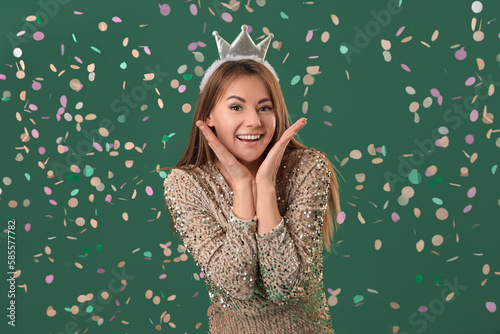 Beautiful woman in crown celebrating Birthday on green background