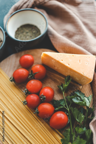 Italian food cooking-tomatoes, basil, pasta and cheese on stone background, top view, copy space