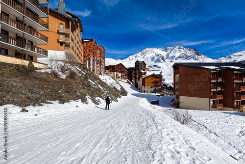 Ski slope in the ski resort of Val Thorens in the French Alps - Snowy track going through a village of wooden chalets in the domain of the Trois Vallées ("Three Valleys"), the largest in the world