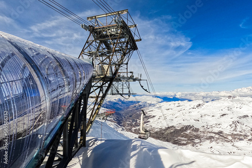 Cable car station located at the summit of "Cime de Caron" above the Val Thorens ski resort in winter - Cantilevered steel structure used for transporting skiers in the French Alps