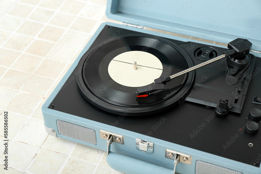 Obraz premium Record player with vinyl disk on beige tile table, closeup
