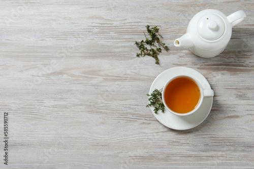 Aromatic herbal tea with thyme on white wooden table, flat lay. Space for text