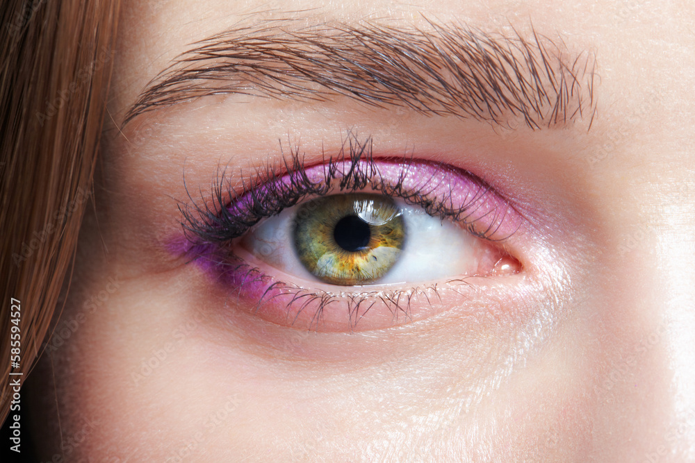 Closeup macro shot of human female eye with pink eyes shadows Closeup macro shot of human female eye with pink eyes shadows
