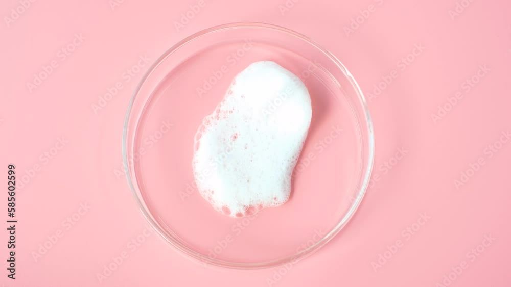 Smear of facial cleansing foam in petri dish on pink background close-up. Smear of facial cleansing foam in petri dish on pink background close-up.