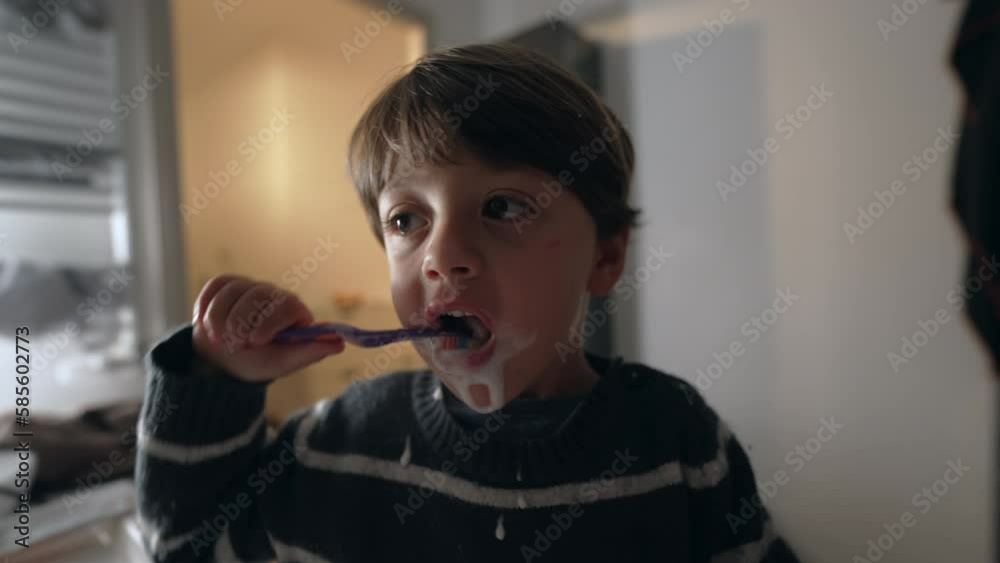 Young boy brushing teeth with toothbrush at night routine. Child brushes dental hygiene in front bathroom mirror before bedtime Young boy brushing teeth with toothbrush at night routine. Child brushes dental hygiene in front bathroom mirror before bedtime