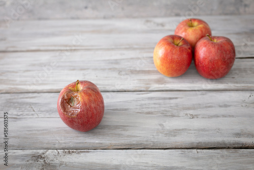 Bild auf Leinwand A red rotten disgusting apple separated of good ones