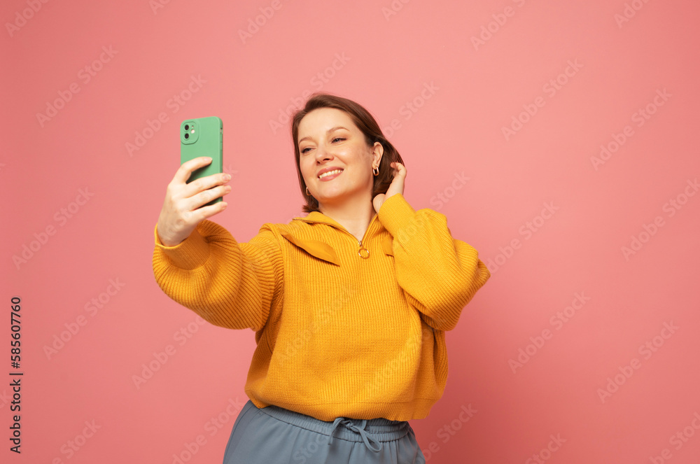 Image of cheerful woman standing isolated over pink background wall talking by mobile phone. Image of cheerful woman standing isolated over pink background wall talking by mobile phone.