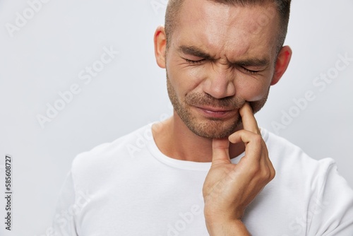 Fotografiet Man toothache, wisdom tooth gum inflammation, in white T-shirt on white isolated
