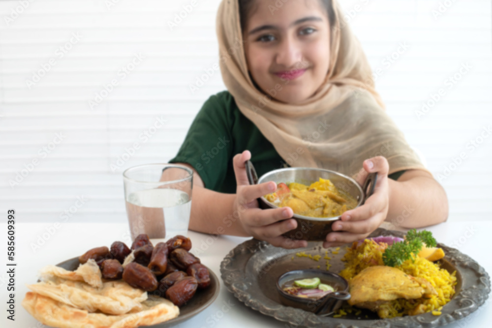 Child Muslim girl showing curry and chicken Biryani, Muslim yellow rice with chicken, Halal food, selective focus