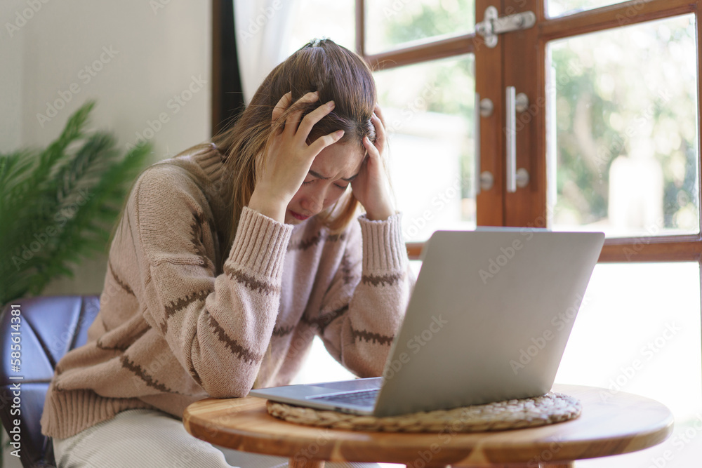 Rest time concept, Women suffering headache and stressful while working on laptop in living room Rest time concept, Women suffering headache and stressful while working on laptop in living room