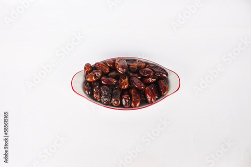 A bowl of dates isolated on a white background, with top view