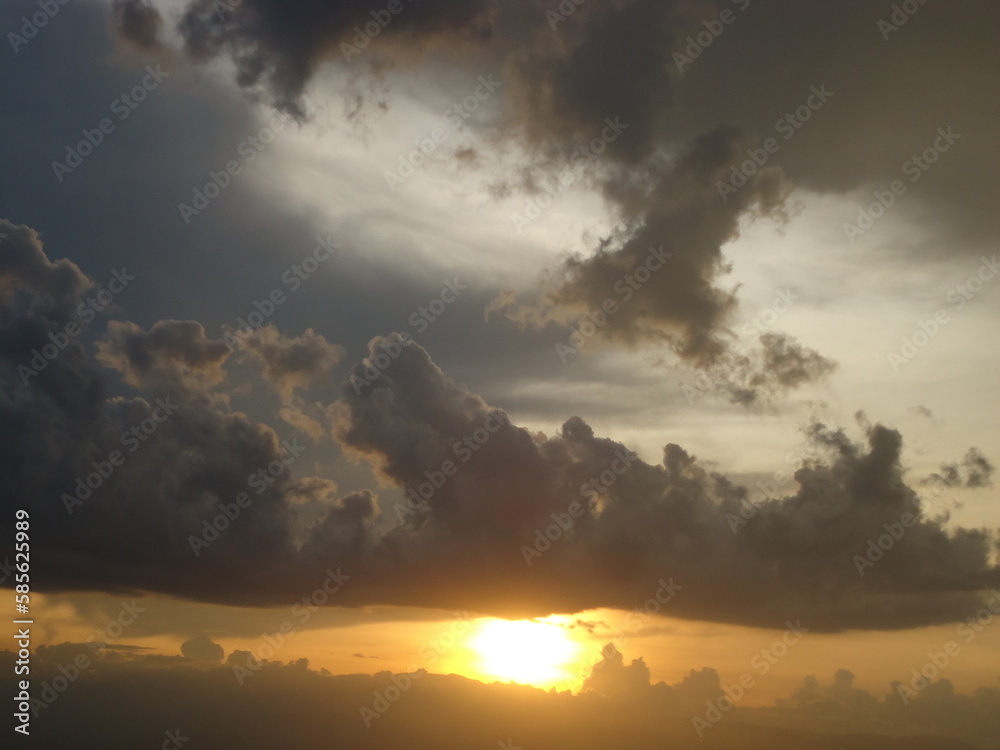 Beautiful sunset in the sky with clouds and rays of light.