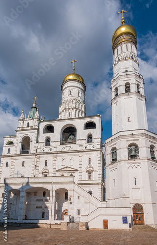 Ivan the Great Bell Tower, with Assumption Belfry on the right in Moscow Kremlin. Blue sky background with sunbeams