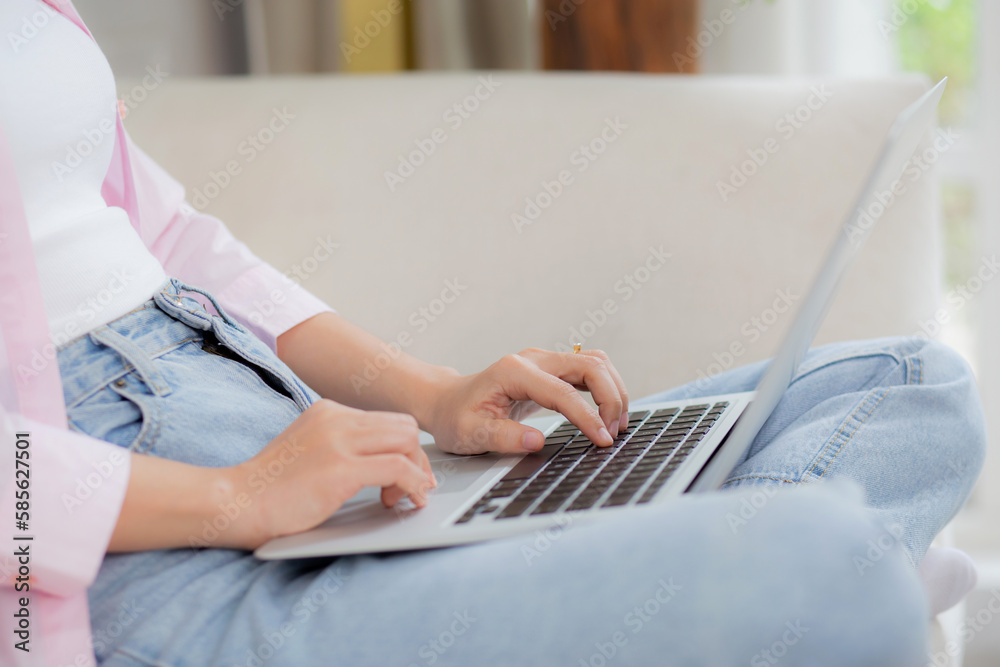 Fototapeta premium Closeup hands business woman work from home with laptop computer online to internet on sofa in living room, freelance girl using notebook sitting on couch with comfort and relax, lifestyles concept.