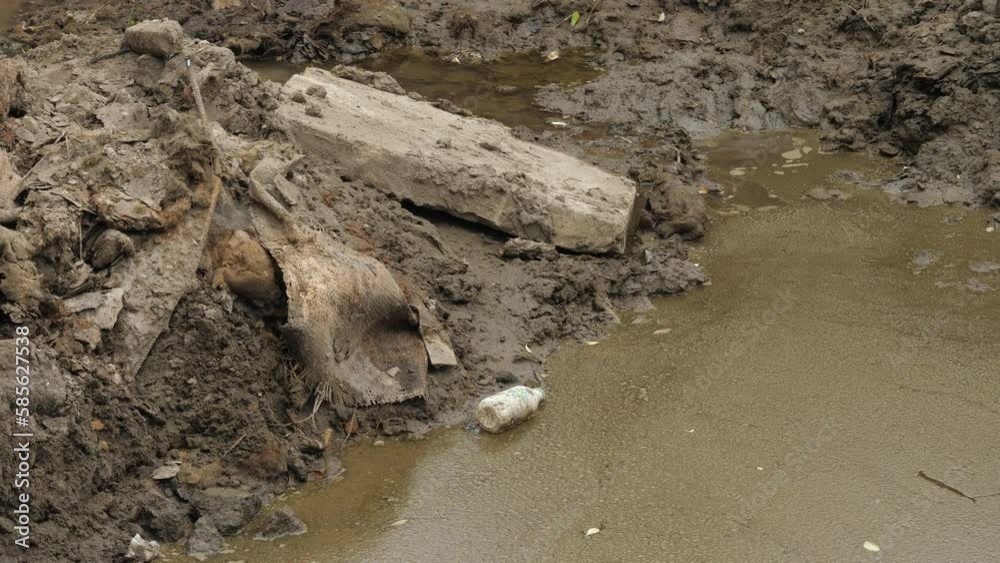 Empty plastic bottles and trash in dirty puddle water. Pollution and environmental problem. Green planet concept Empty plastic bottles and trash in dirty puddle water. Pollution and environmental problem. Green planet concept