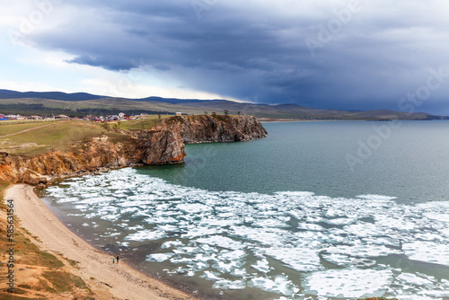 Baikal Lake in Spring time. View of the sandy beach with melting ice near the village of Khuzhir. Spring landscape. Nature background. Travels and outdoors