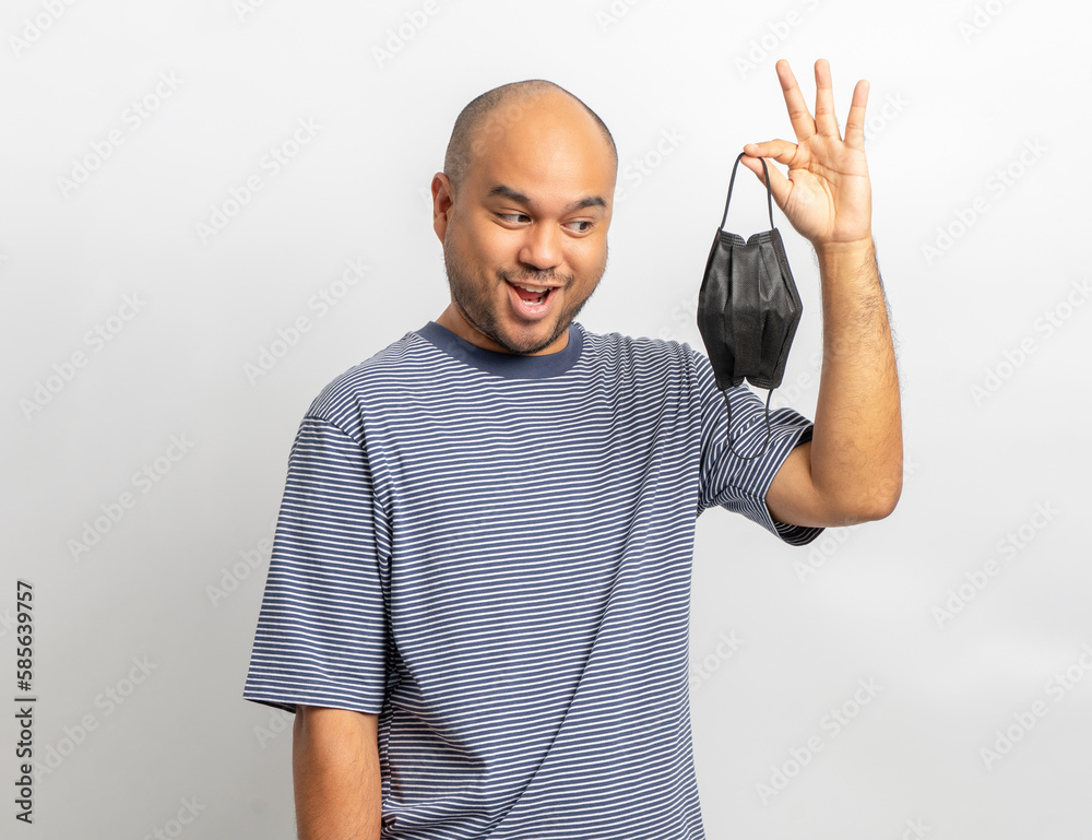 Naklejka premium Handsome young man smiling and happy with protection mask. Charming male standing with on isolated white background. Asian people pose with white backdrop.