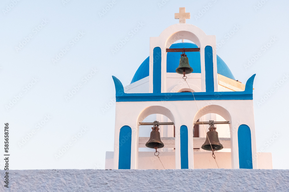 White and blue bell tower of a church in santorini in greece