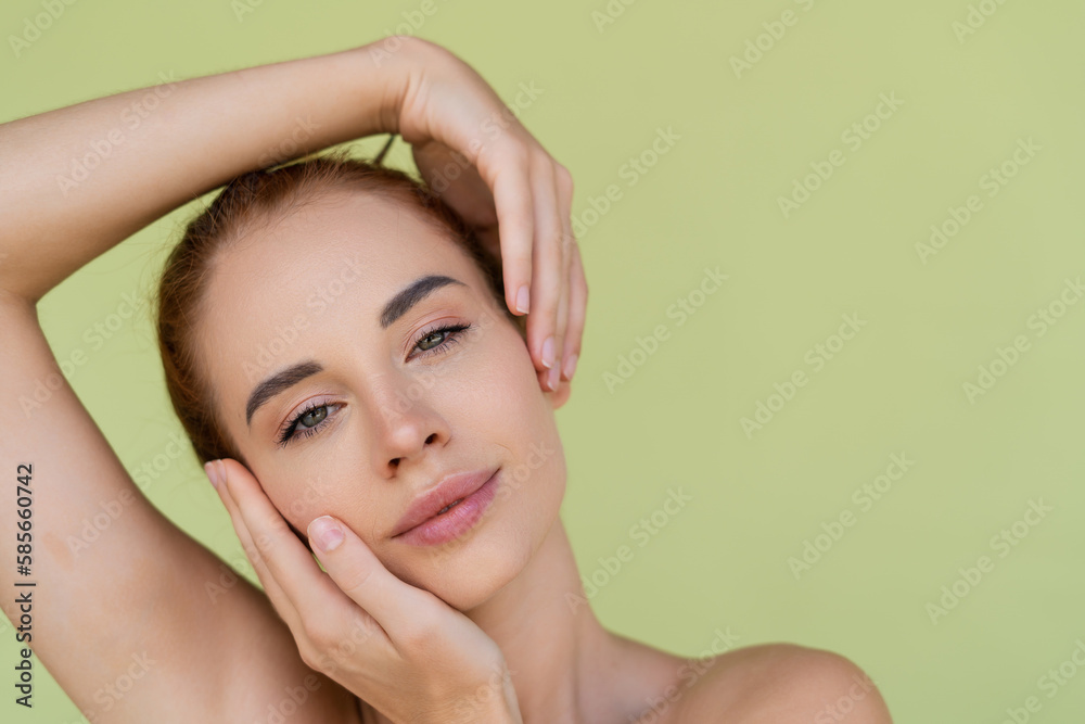 Naklejka premium Beauty portrait of young topless red hair woman with bare shoulders on green background with perfect skin and natural makeup