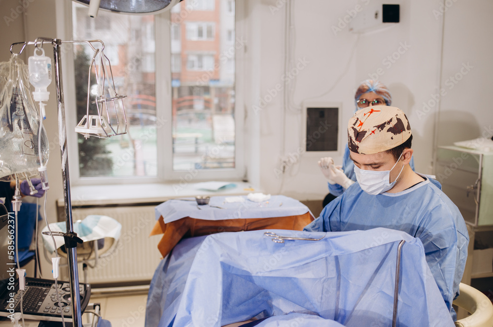 Confident surgeon wearing protective mask looking at the patient and feeling concentrated during the operation. Medicine concept. Confident surgeon wearing protective mask looking at the patient and feeling concentrated during the operation. Medicine concept.