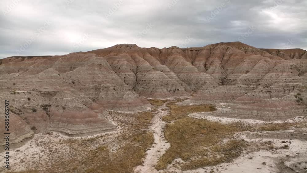 Fast moving aerial moving through the Badlands National Park among the dry and rugged canyon.