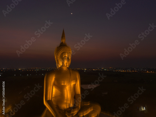 aerial view The moon on the head of golden big Buddha.  the Biggest Buddha in the world at wat Maung Angtong Thailand. scenery sky in twilight background.the one famous landmarks in Thailand. 