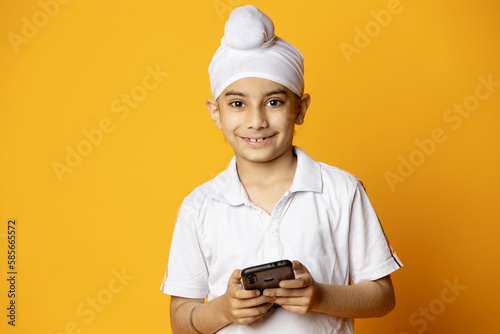 Happy indian kid holding phone and looking toward the camera