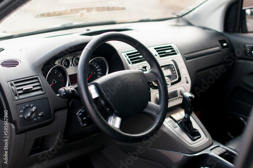 Modern car interior, black perforated leather, aluminum, details controls, leather steering wheel. © ARTUR