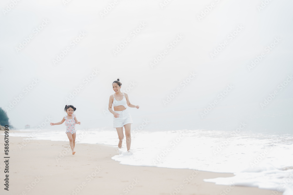 happy time of mom and daughter in dress white walking and run play on the beach morning time with blur background