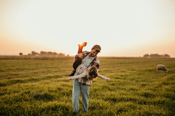 Happy family on the summer walk! Father and daughter walking outdoors on an animal field and enjoying the beautiful nature.