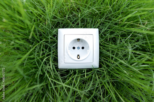 White electrical outlet on green grass photo