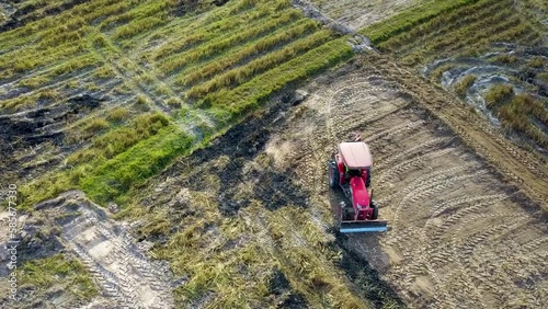 Close up of fields combine and tractor harvest the rice, Plowed field prepared for planting crops in spring.