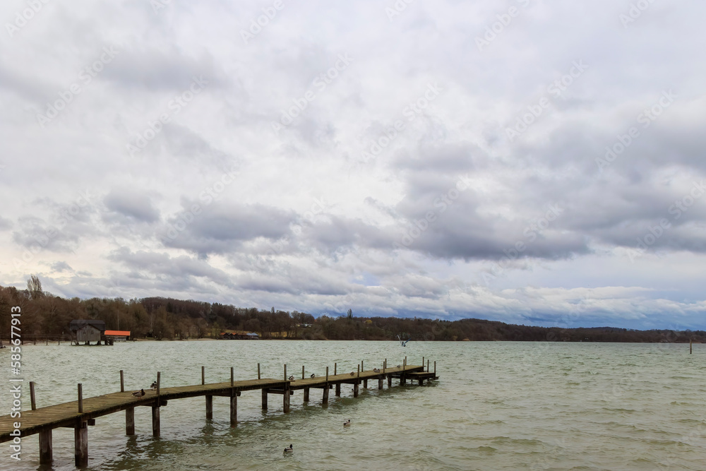 Boat jetty in Stegen am Ammersee on a cold windy day with cloudy sky