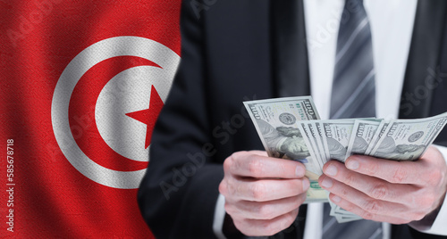 Hands holding dollar money on flag of Tunisia