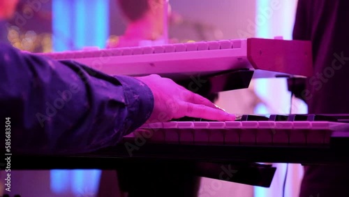 Man playing keyboard performance on stage. 