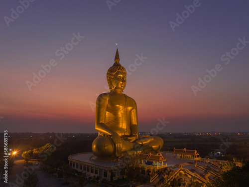 aerial view The moon on the head of golden big Buddha.  the Biggest Buddha in the world at wat Maung Angtong Thailand. scenery sky in twilight background.the one famous landmarks in Thailand. 