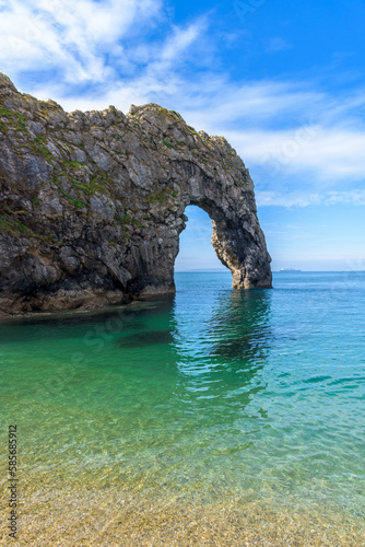 Durdle Door natural arch with its bay and beach. Clear sea water near Lulworth, Jurassic Coast, Dorset, south of England.