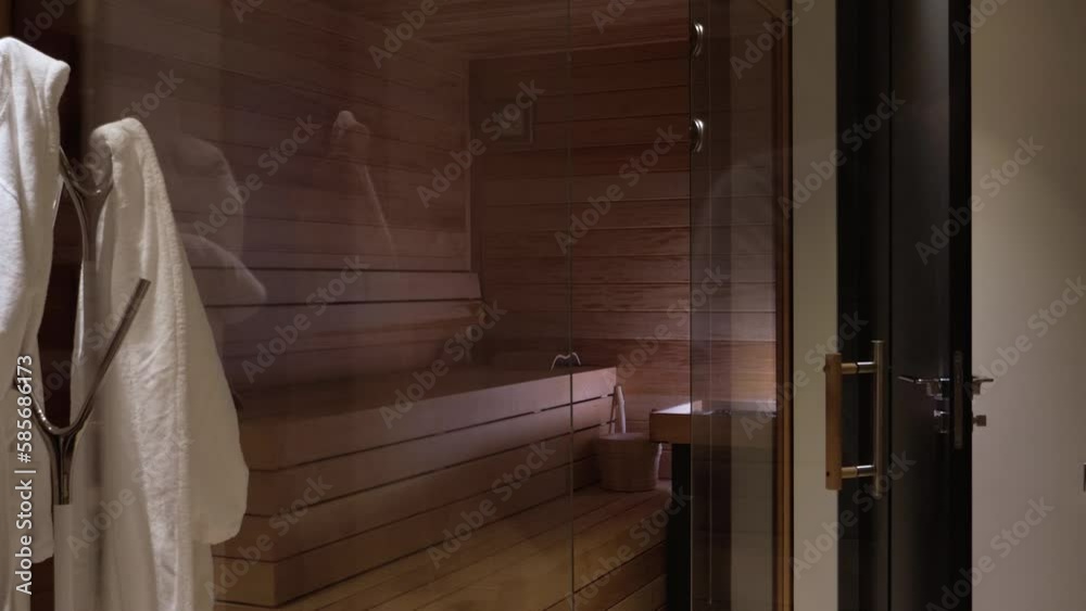 Revealing shot of a wooden sauna with dressing gowns hanging in a villa in Mougins Revealing shot of a wooden sauna with dressing gowns hanging in a villa in Mougins