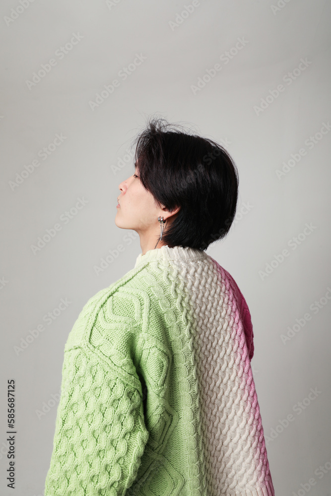 Cropped portrait of young man with earrings posing over white wall. Mock-up. Cropped portrait of young man with earrings posing over white wall. Mock-up.