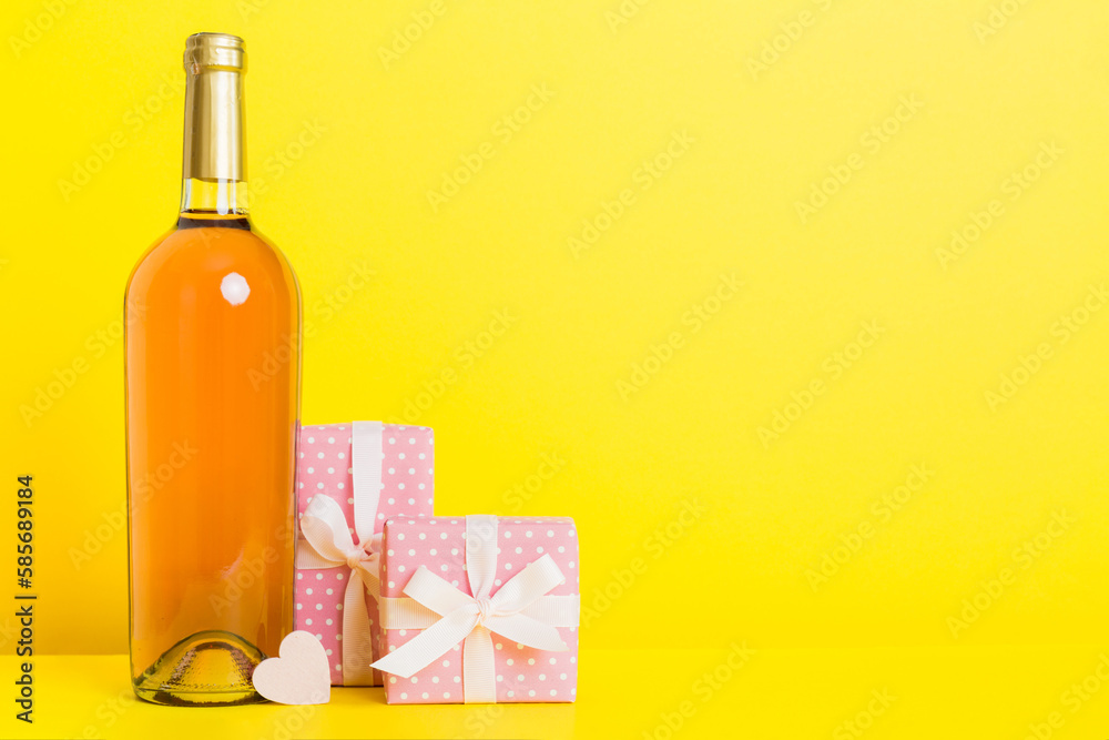 Bottle of wine on colored background for Valentine Day with gift box. Heart shaped with presrnt box perspective view with copy space