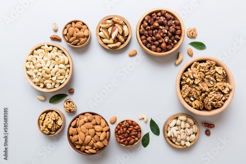 mixed nuts in wooden bowl. Mix of various nuts on colored background. pistachios, cashews, walnuts, hazelnuts, peanuts and brazil nuts