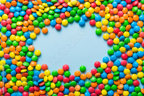 Mixed collection of colorful candy, on colored background. Flat lay, top view. frame of colorful chocolate coated candy © sosiukin