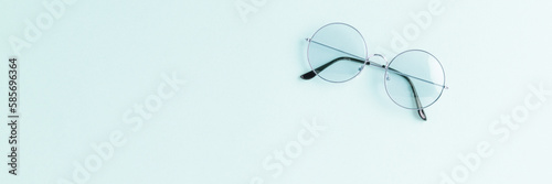 Round sunglasses on pink background. Flat lay