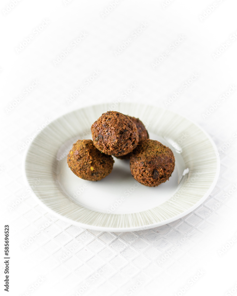 Falafel balls on white plate and white background.