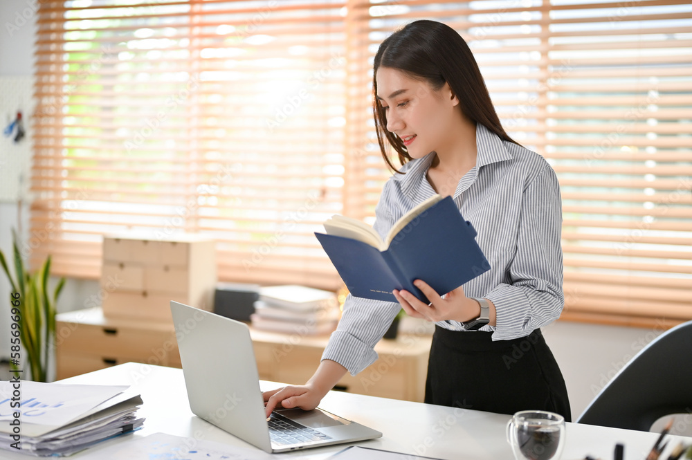 Smart and focused Asian businesswoman working on her business assignment at her desk. Smart and focused Asian businesswoman working on her business assignment at her desk.