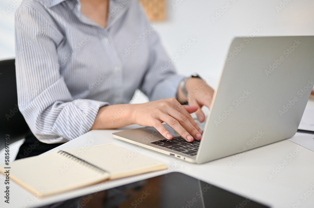 Cropped image of a professional businesswoman using her laptop at her desk Cropped image of a professional businesswoman using her laptop at her desk