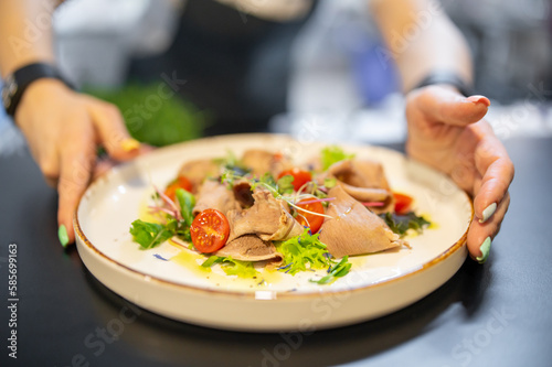 Chef cooking Beef tongue salad with fresh vegetables on restaurant kitchen