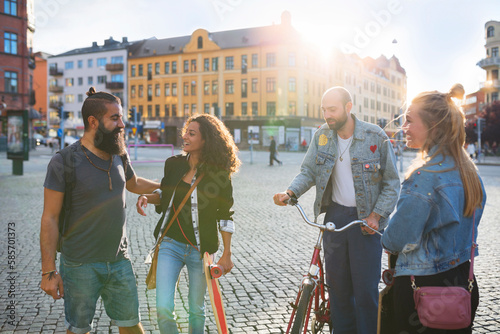 Smiling friends talking at town square