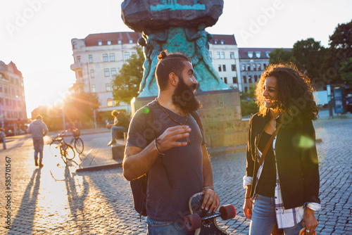 Smiling friends talking in town square photo